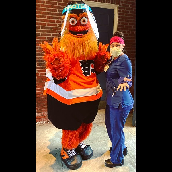 MSN student Carly Campbell is showing Philadelphia Flyers mascot, Gritty, how to wear personal protective gear